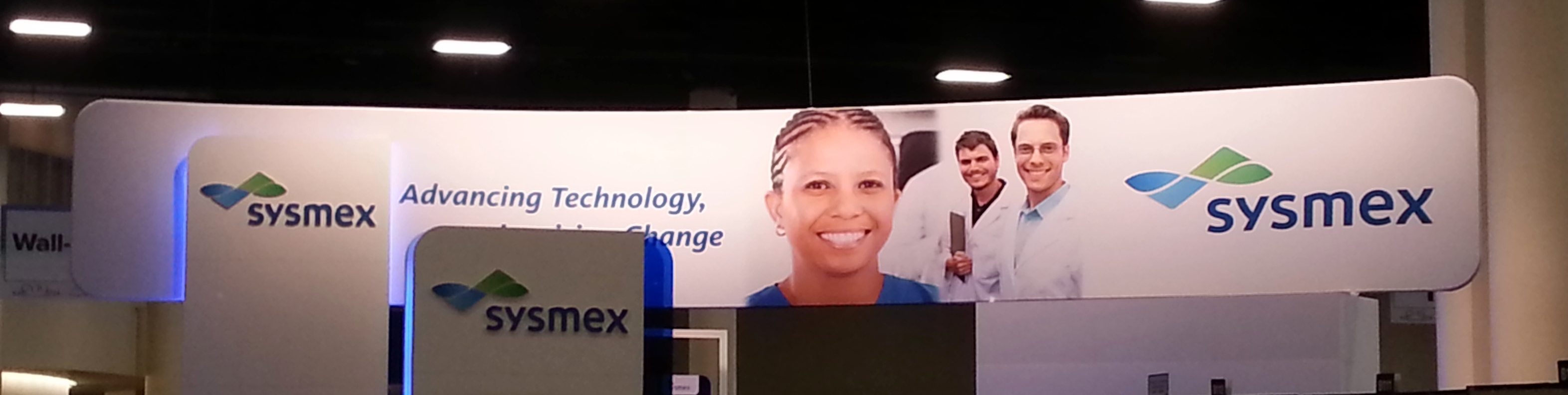 sysmex wide curved trade show hanging sign suspended above booth